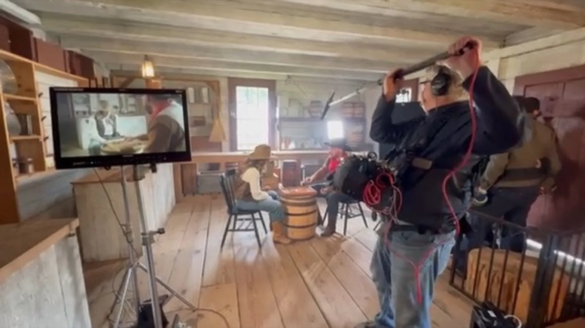 Sound mixer with boom operator on location — monitor, wireless rig, and headphones