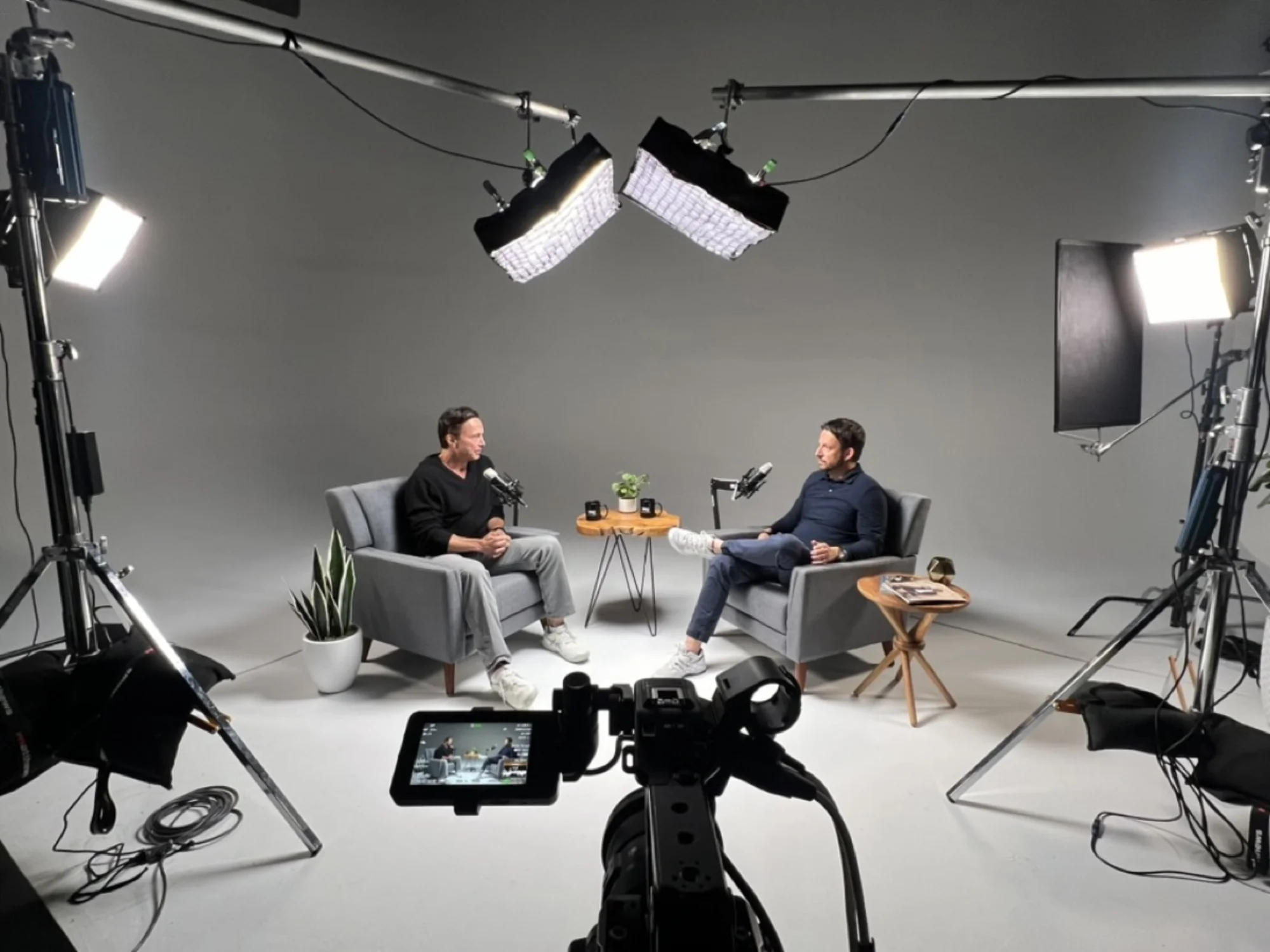 Studio interview setup with two subjects, full lighting rig and camera monitors