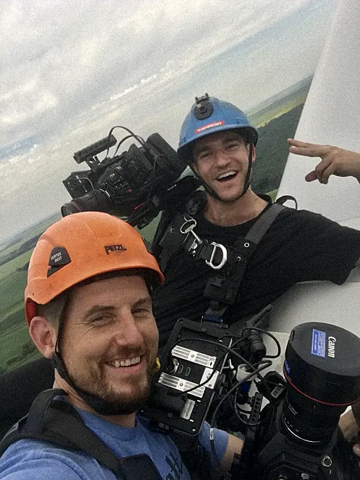 Two Element 7 crew members with cameras at the top of the wind turbine
